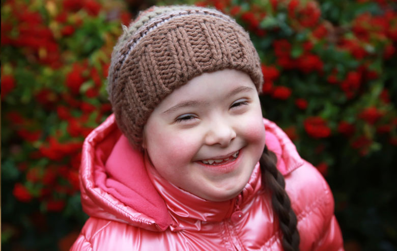 Girl smiling at camera outside.