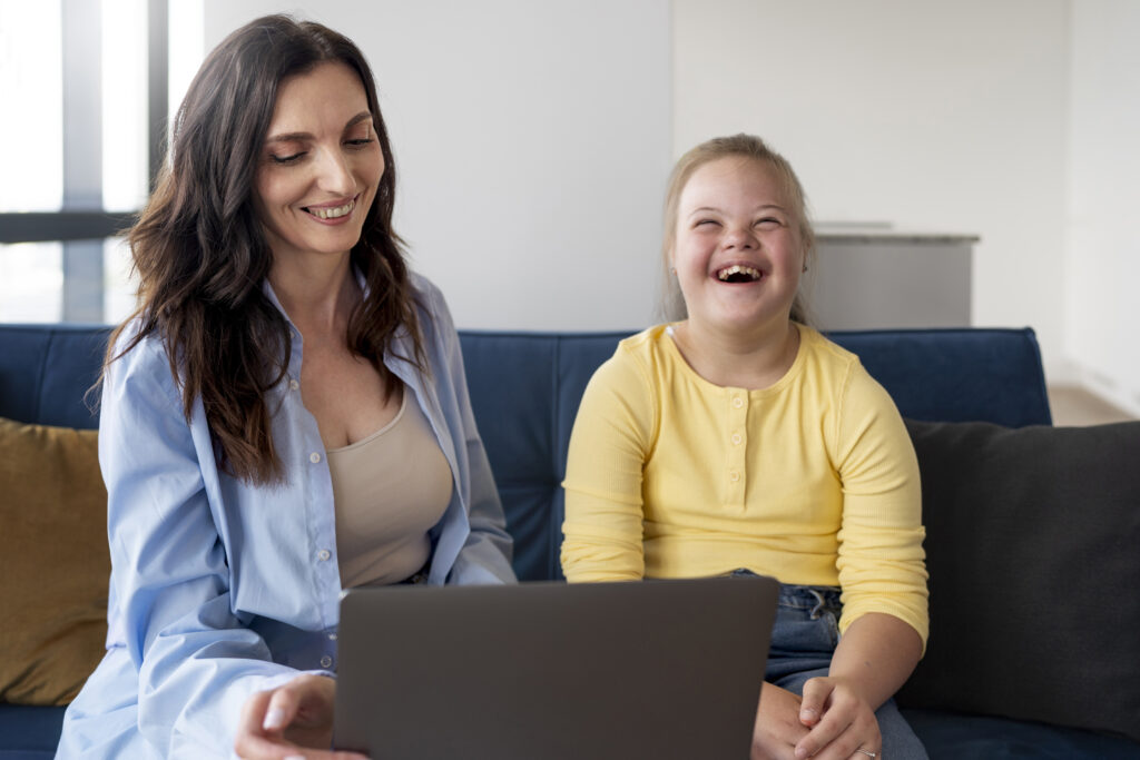 Une mère et sa fille atteintes du syndrome de Down devant un ordinateur portable